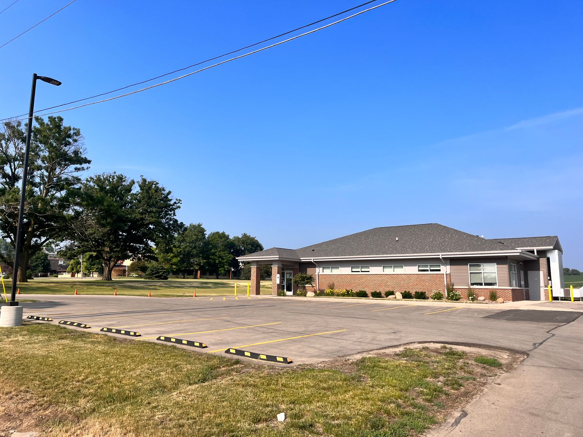 A brick building with a parking lot in front of it.