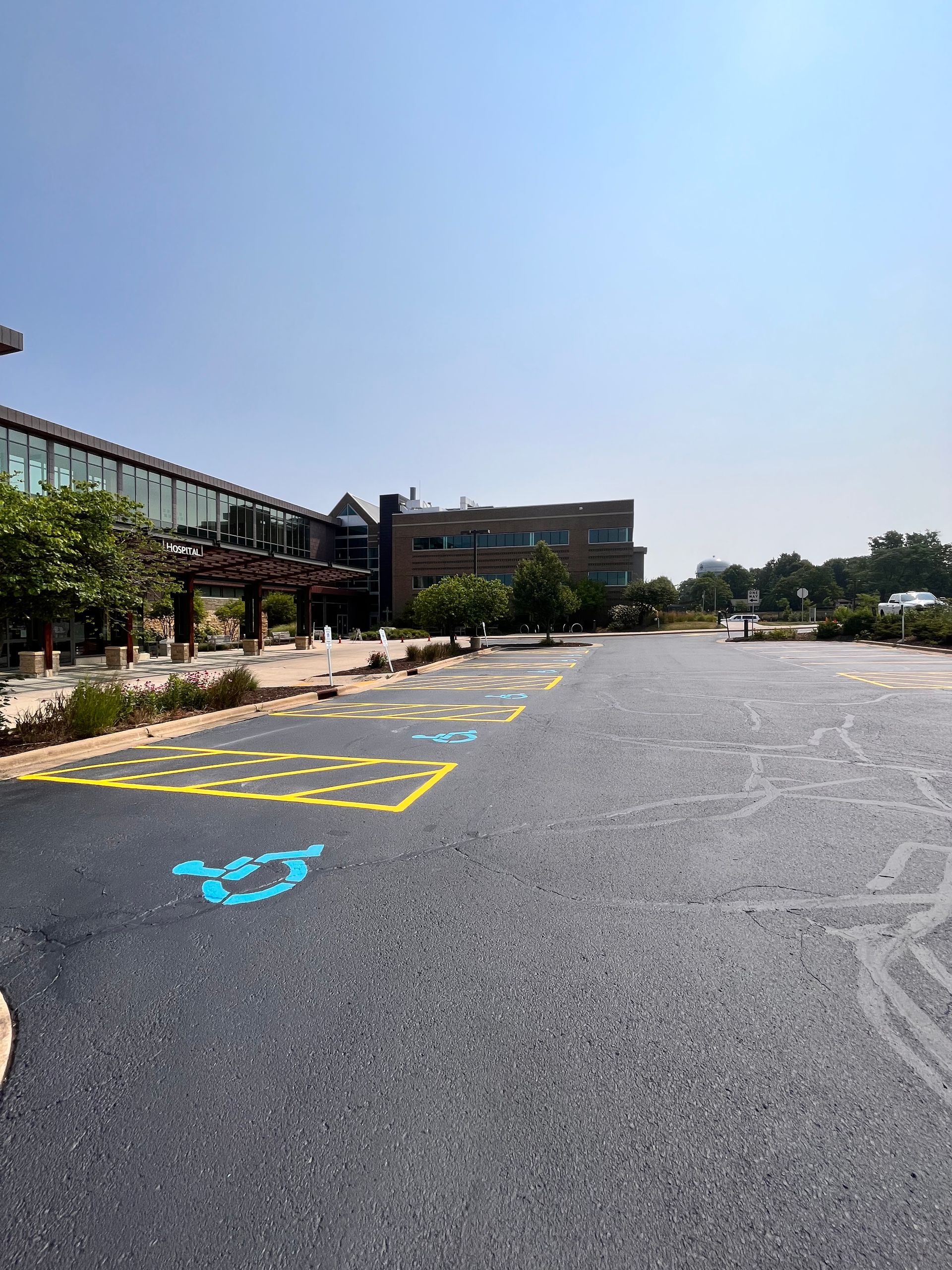 A parking lot with handicapped parking spaces and a building in the background