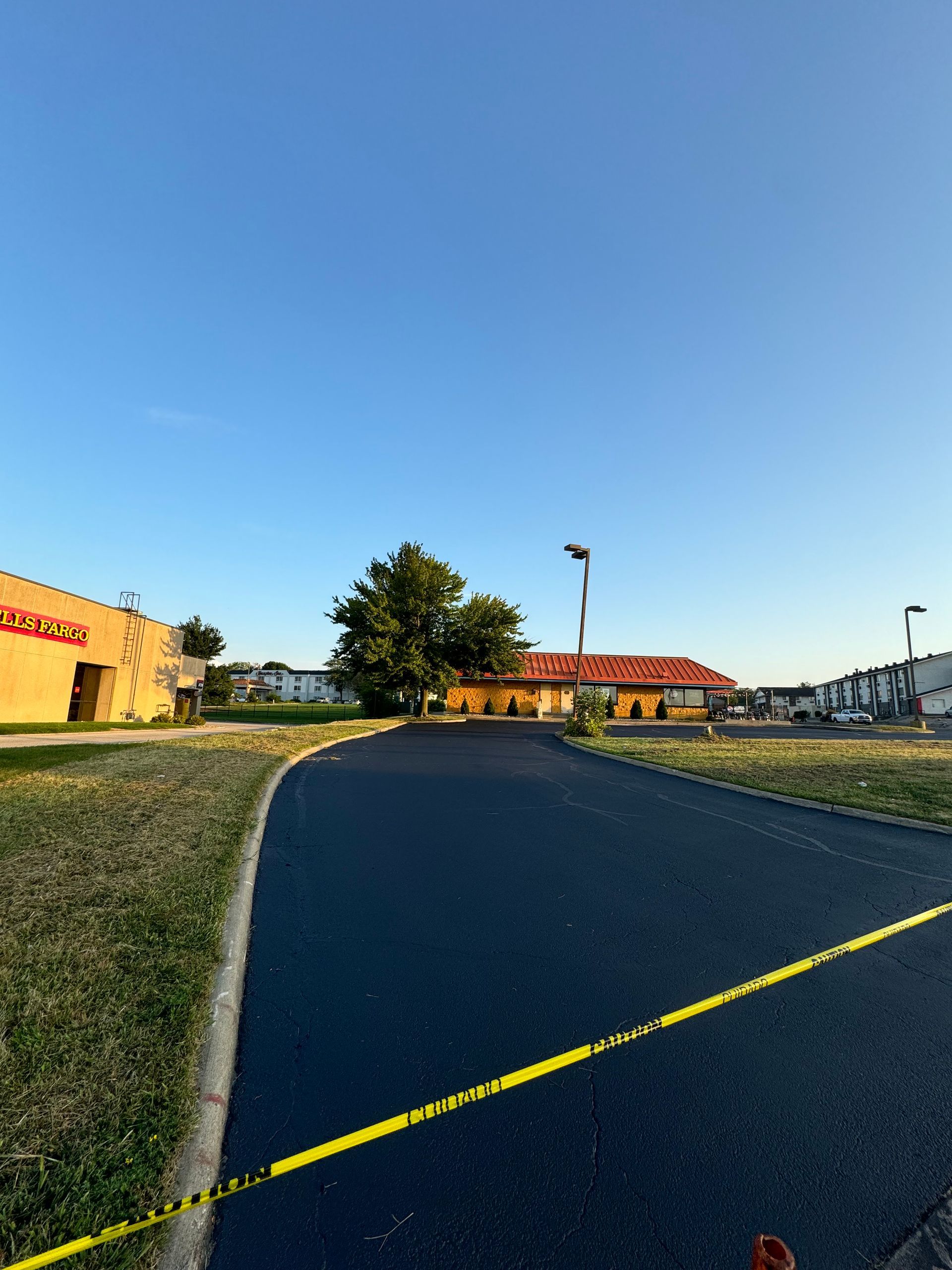 A road with a yellow line on it and a building in the background.