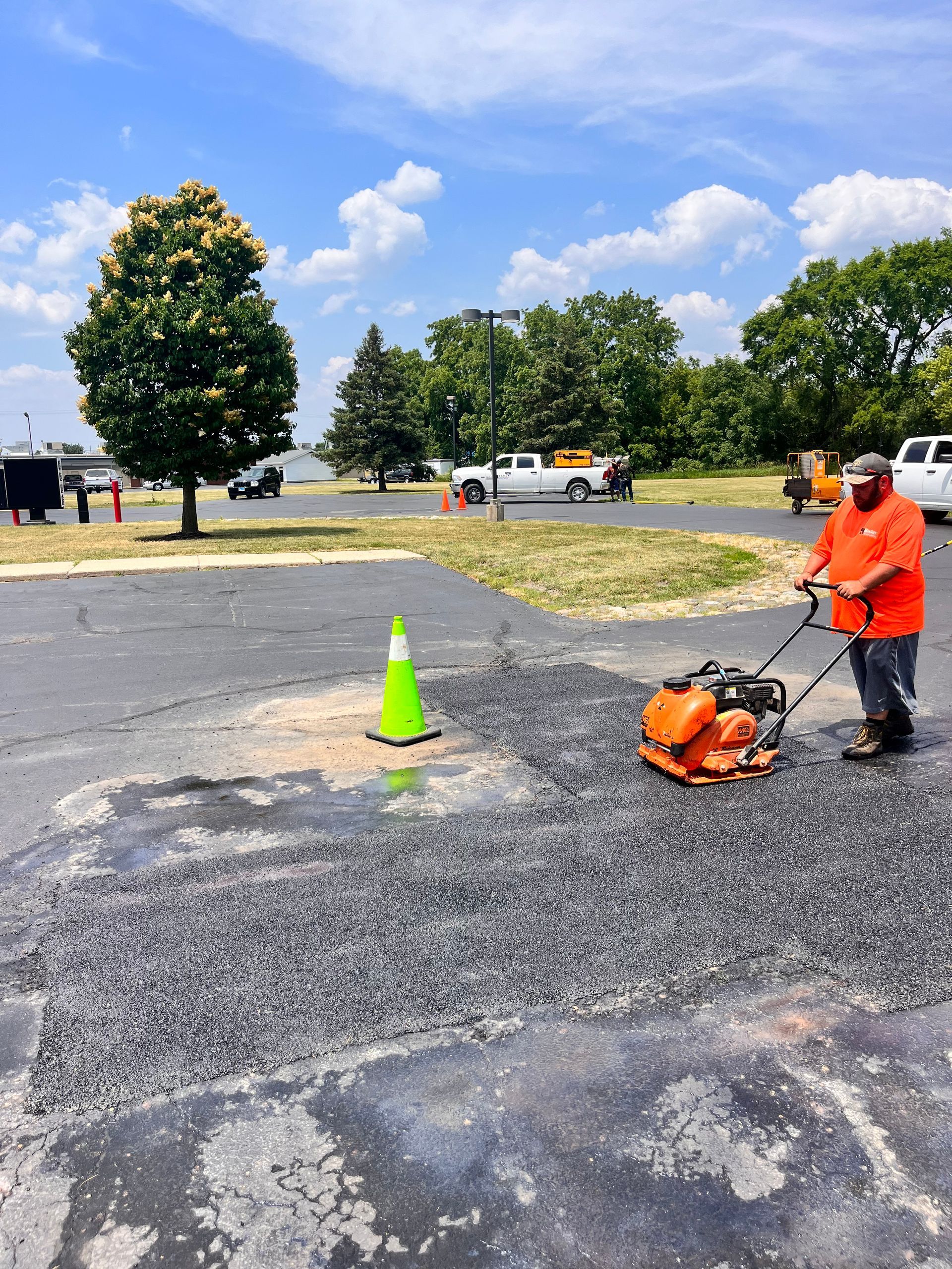 A man is standing in a parking lot using a machine
