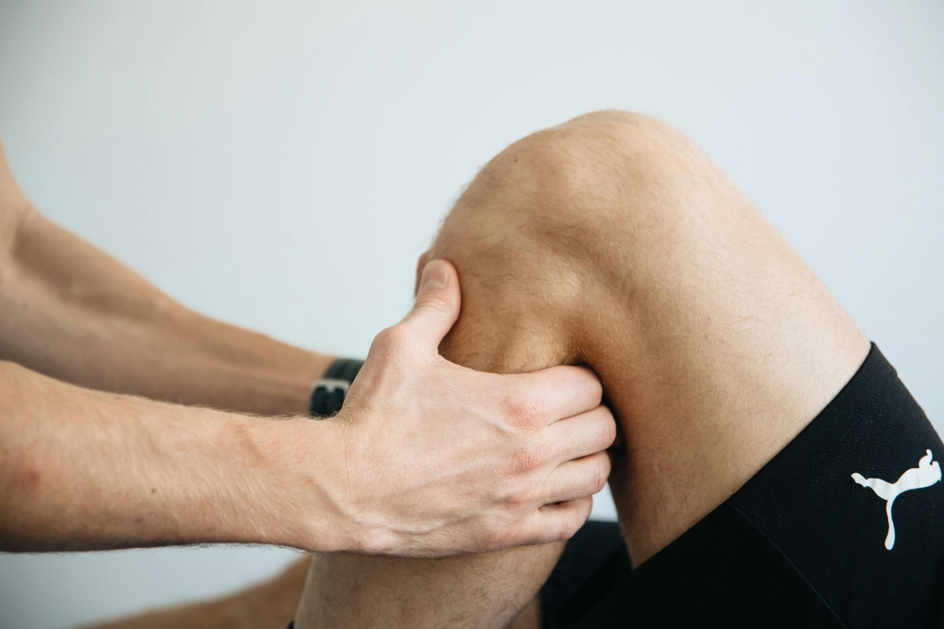 A person is holding their knee in pain.