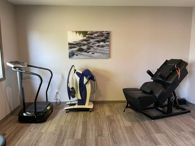 A room with a treadmill and a chair in it