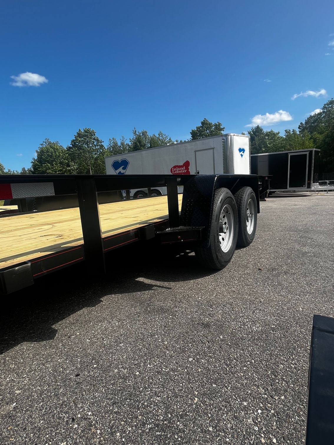 A flatbed trailer is parked on the side of the road.