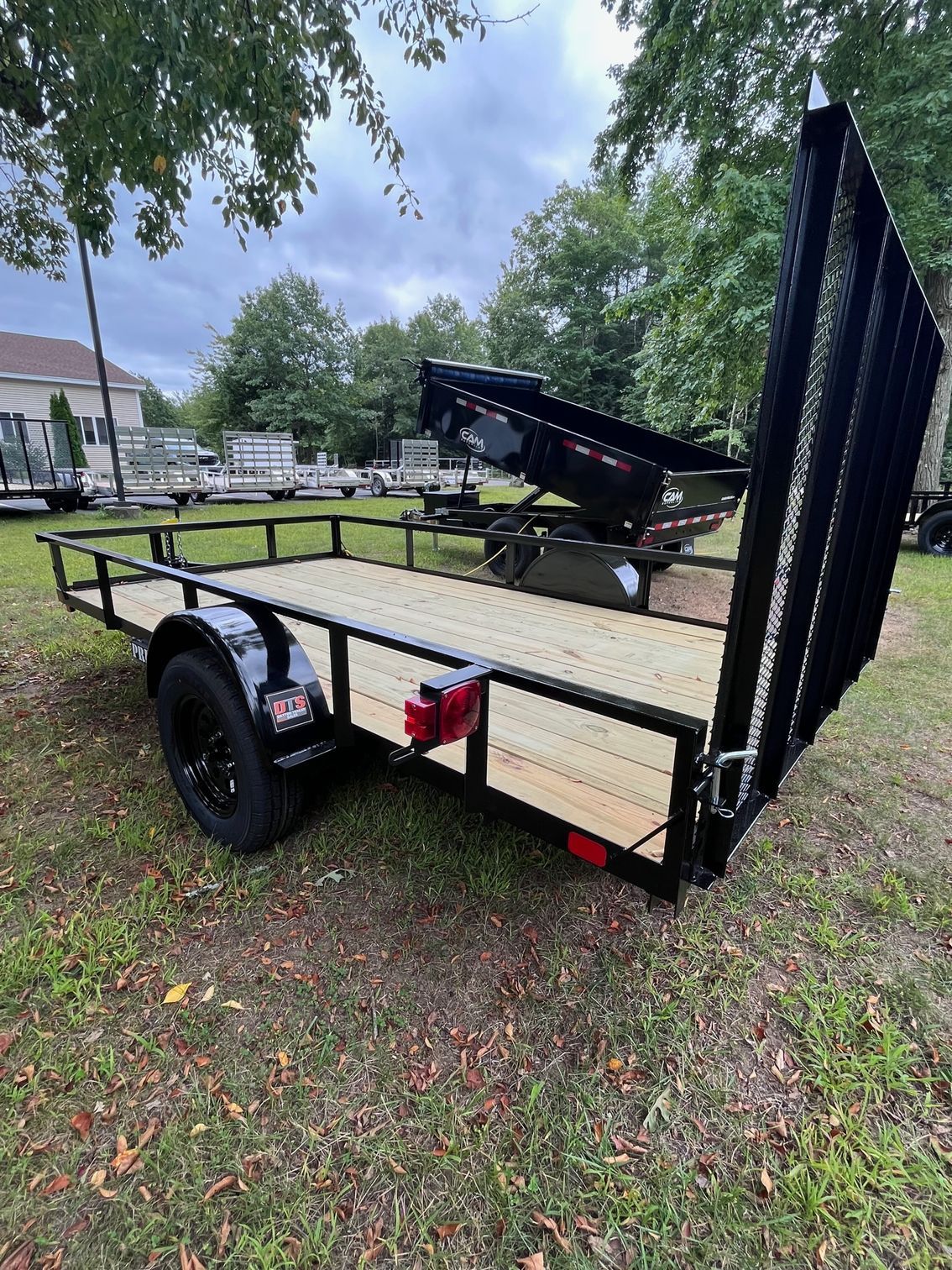 A trailer with a boat on top of it is parked in a grassy field.