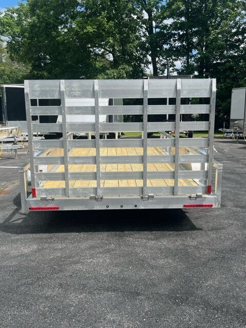 A trailer with a wooden deck is parked in a parking lot.