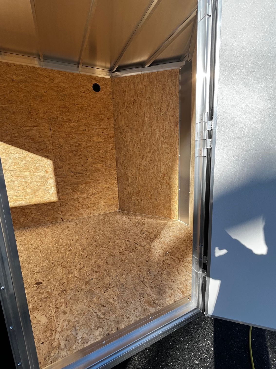 A room with a wooden floor and a metal door.