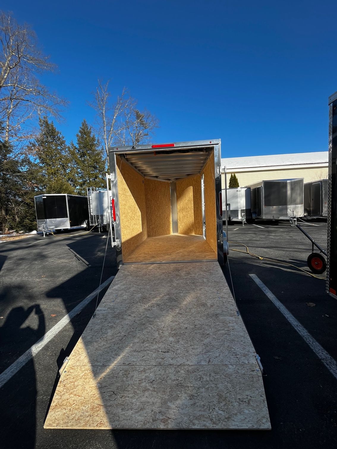 A trailer is parked in a parking lot with the door open.