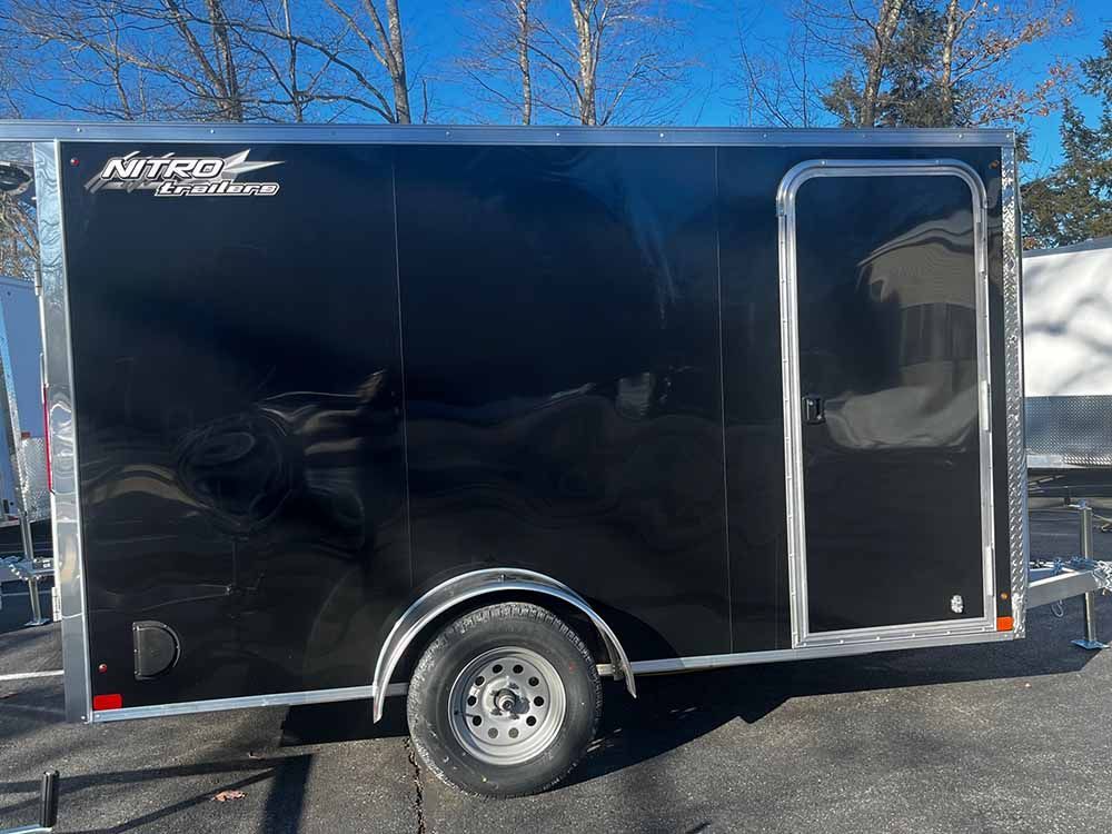 A black trailer is parked in a parking lot.