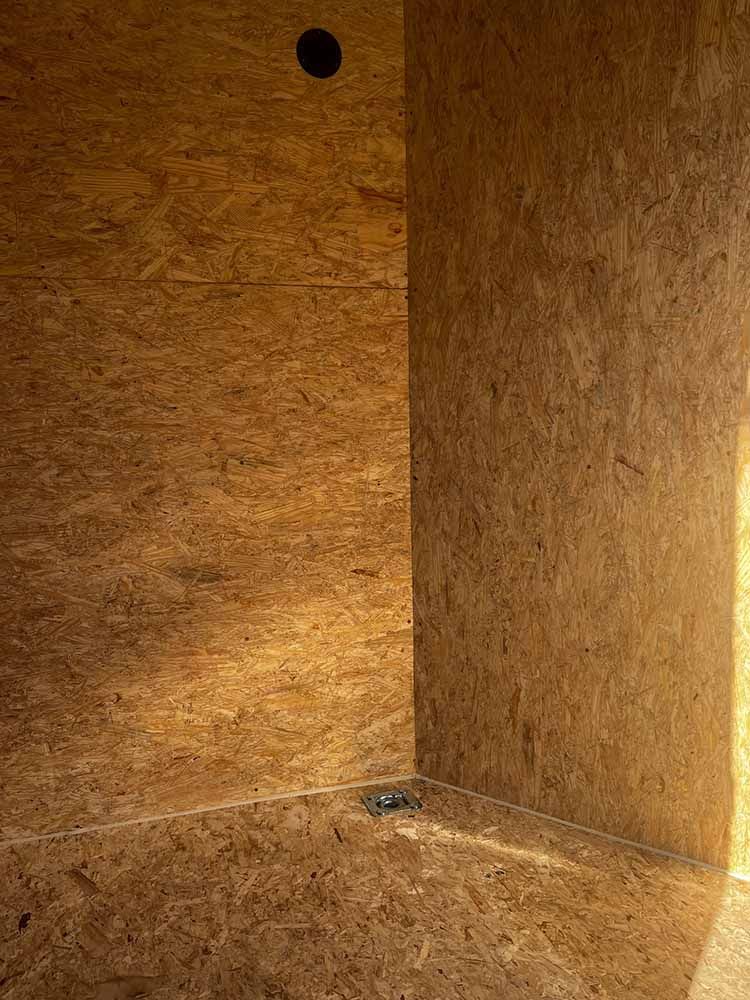 A corner of a room with a wooden wall and floor.
