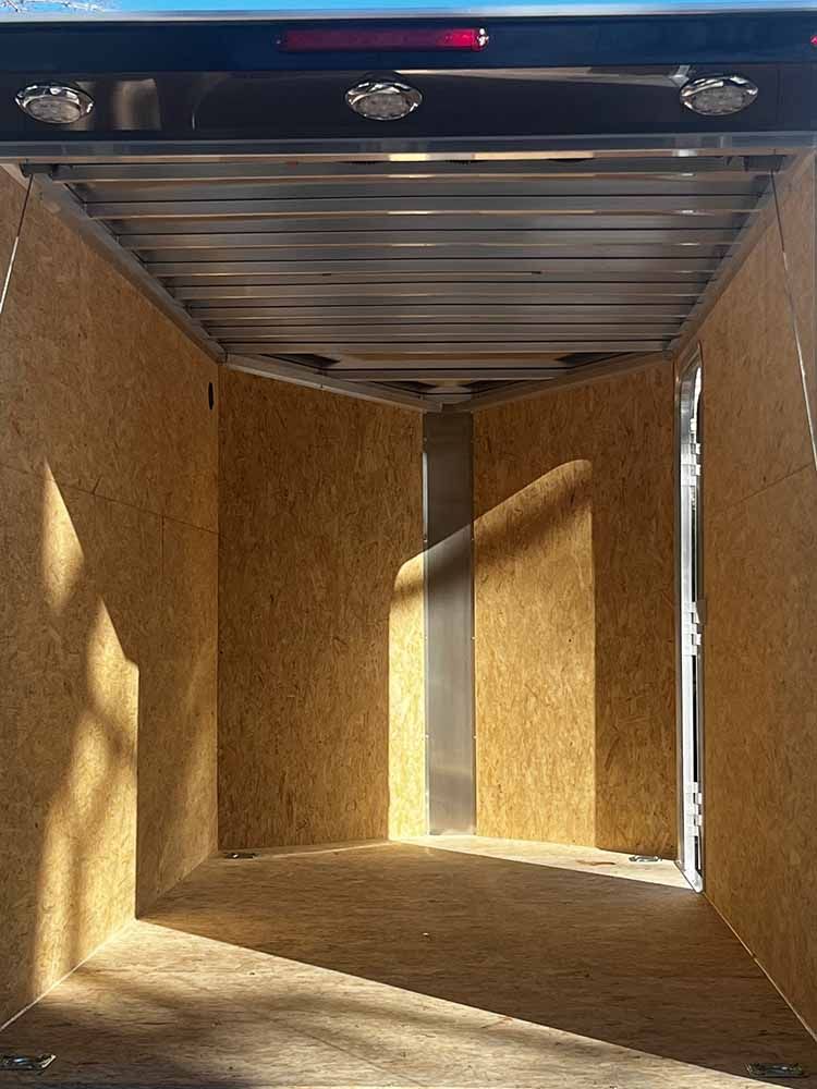 The inside of a trailer with wooden walls and a metal roof.