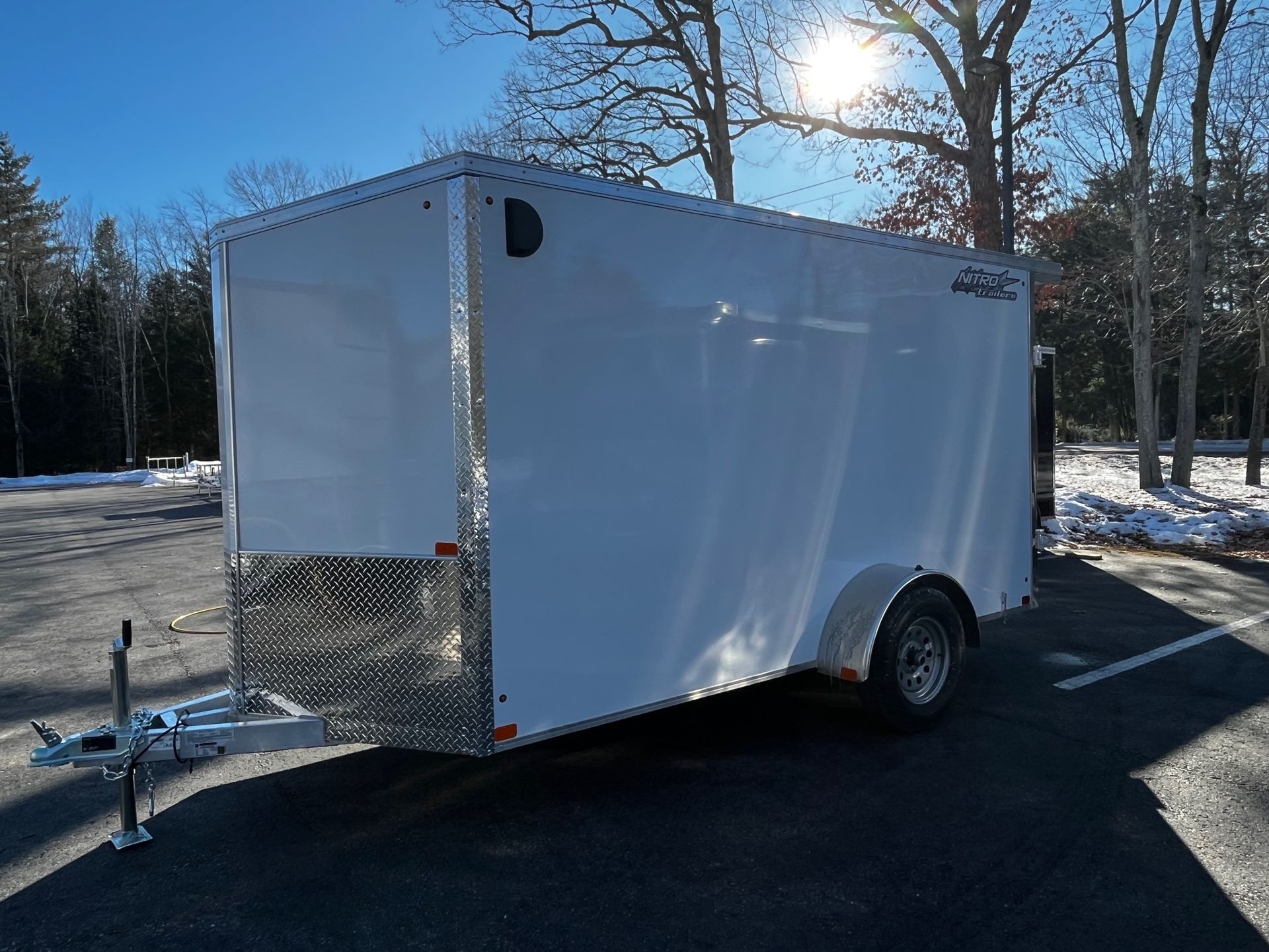 A white trailer is parked in a parking lot.