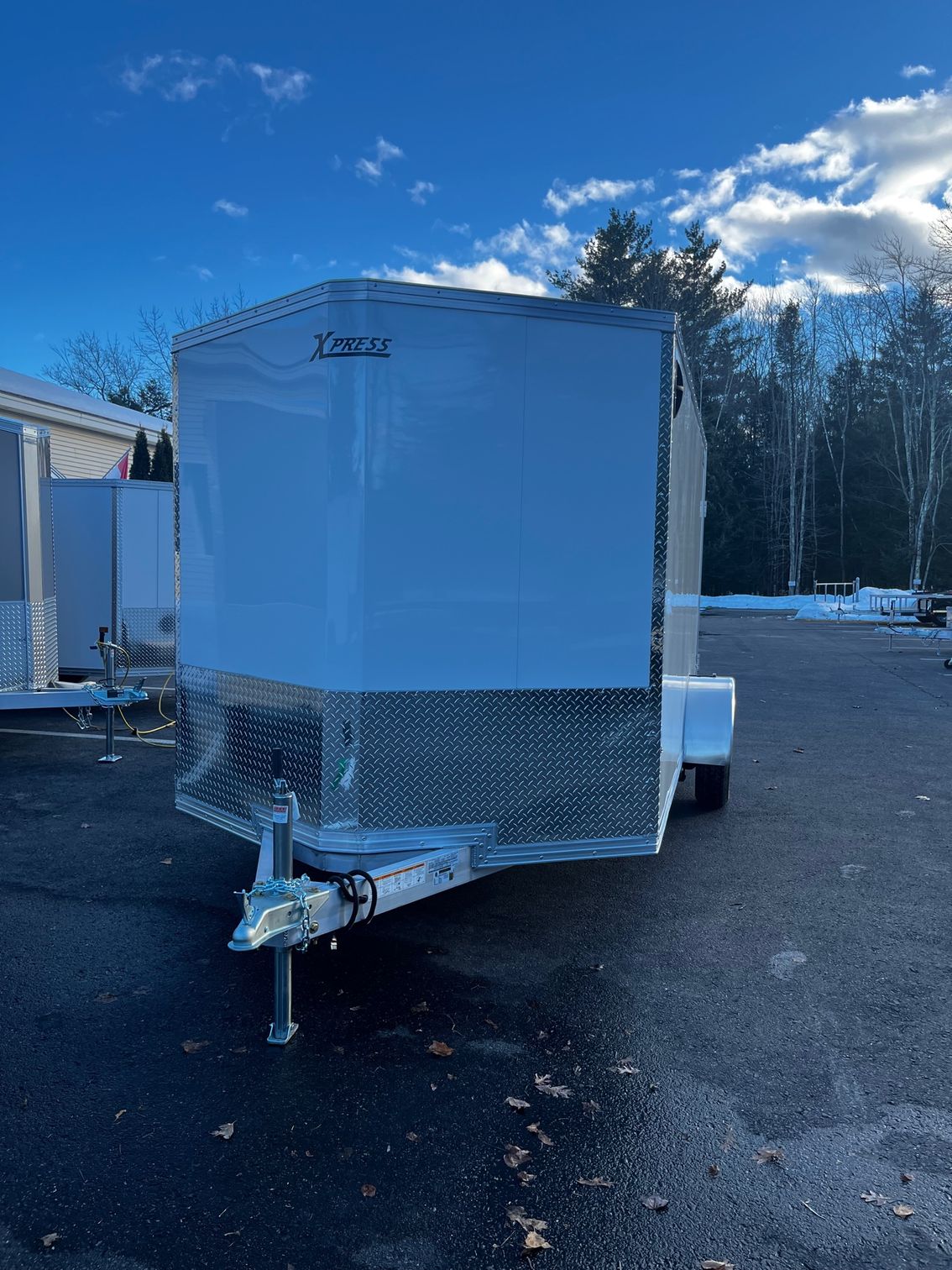 A white trailer is parked in a parking lot