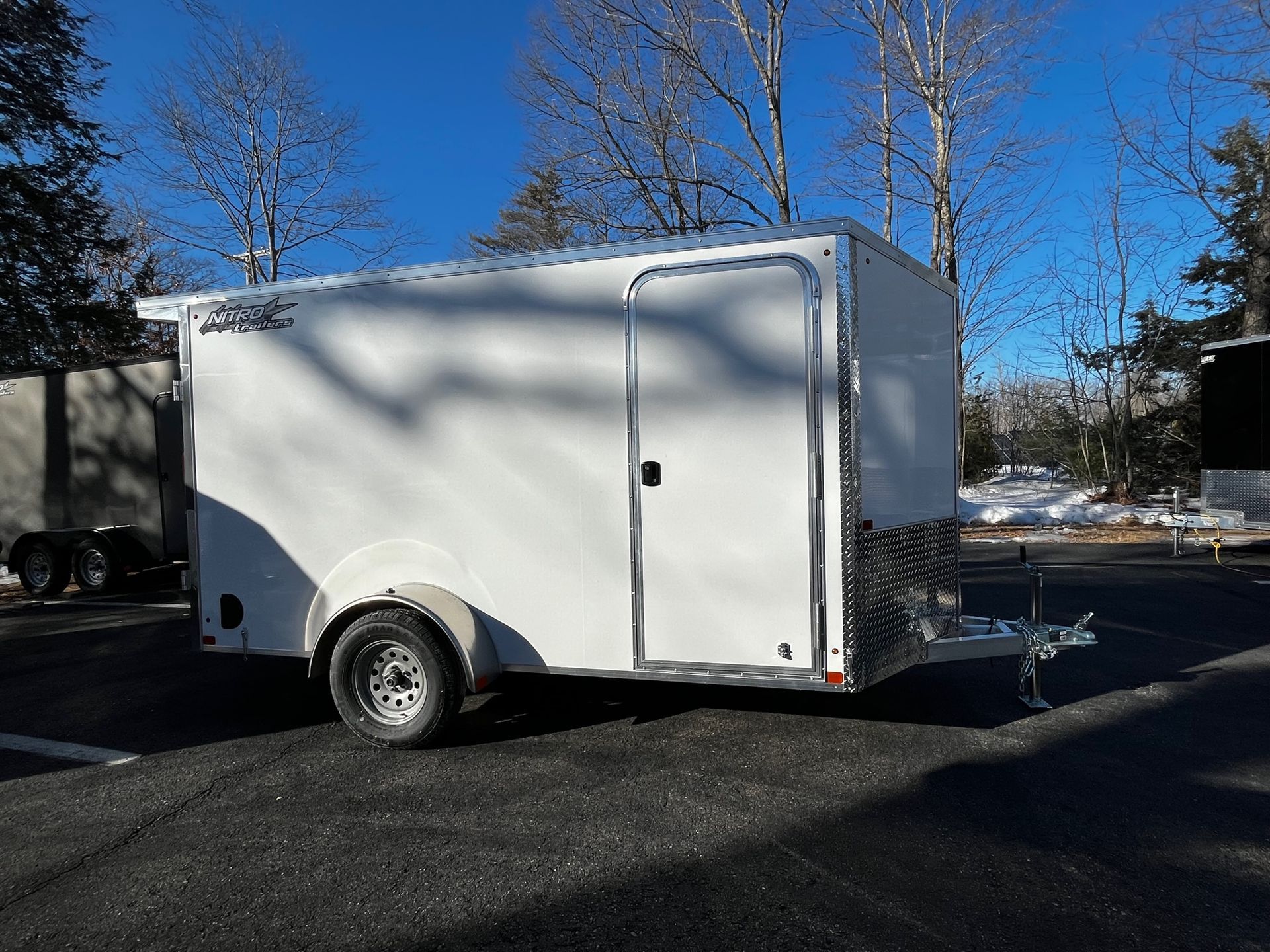 A white trailer is parked on the side of the road.