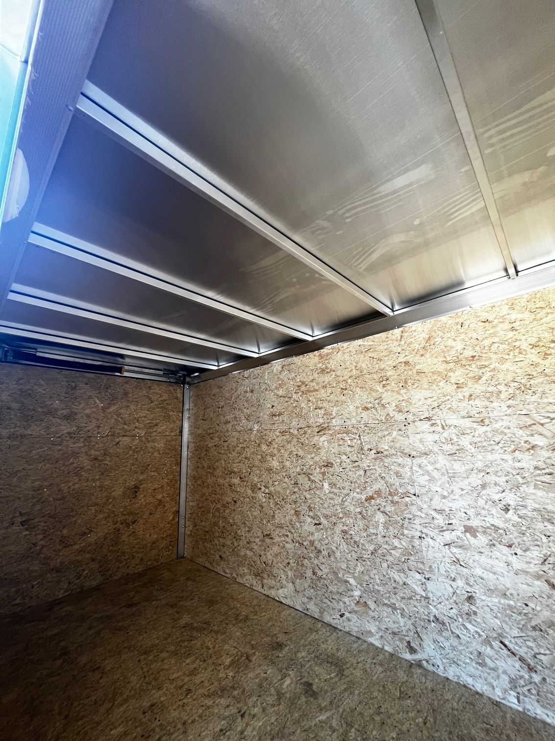 A large empty room with wooden walls and a metal ceiling.