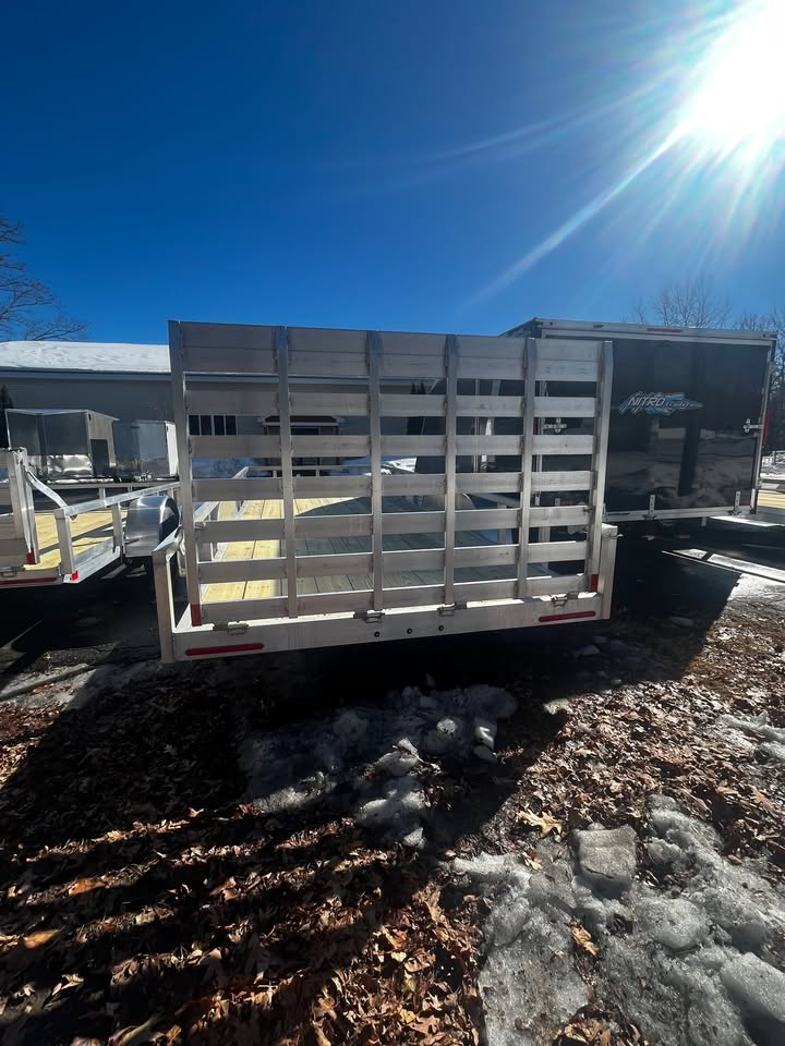 A trailer with a fence on the back is parked in the snow.