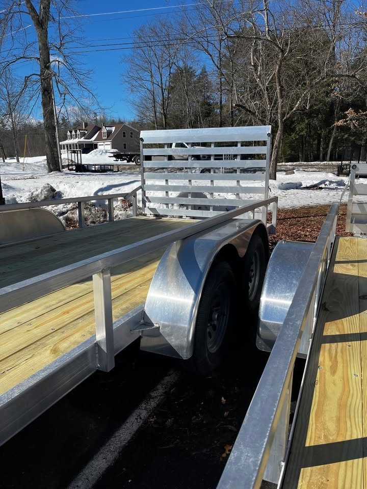 A trailer is parked on a wooden deck in the snow.