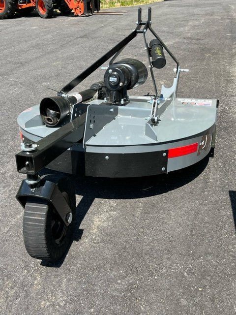 A lawn mower is parked on the side of the road