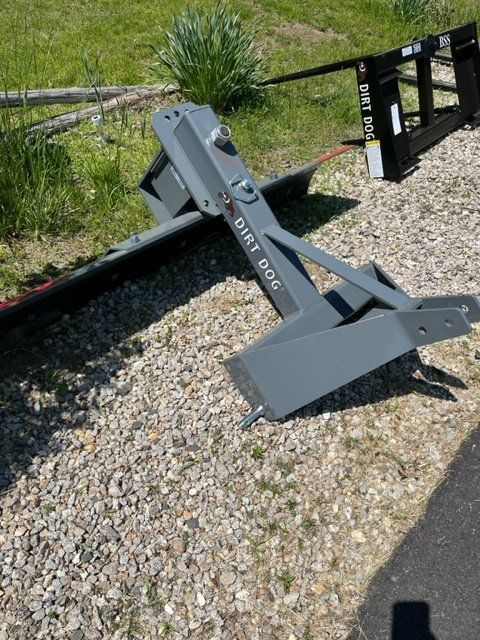 A dirt dog is sitting on a gravel road