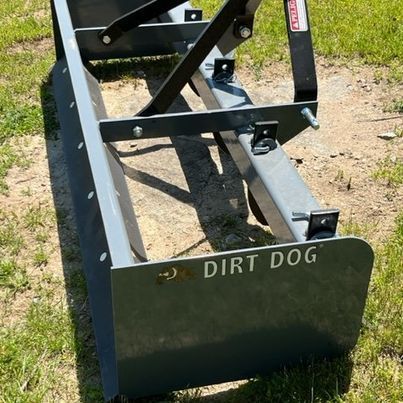 A dirt dog is sitting in the grass on the ground