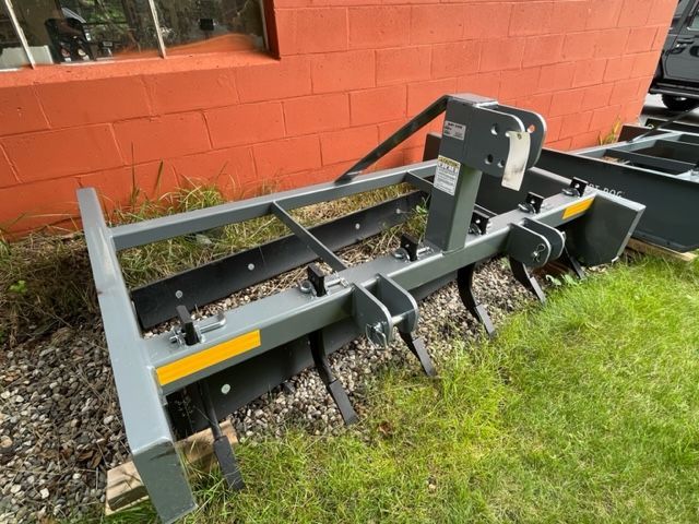 A machine is sitting in the grass in front of a brick building.