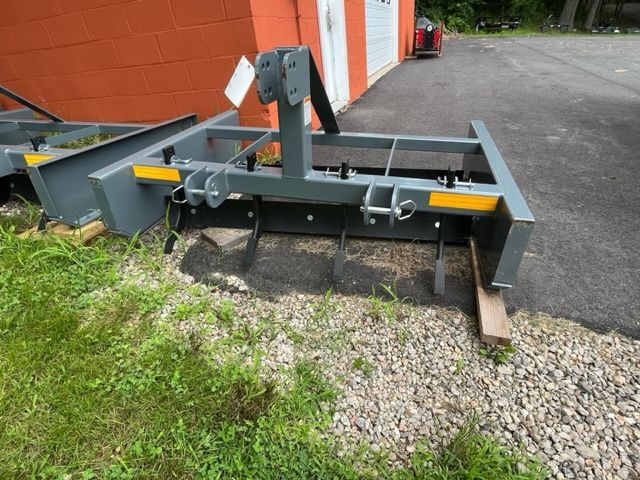 A machine is sitting on the ground in front of a garage.