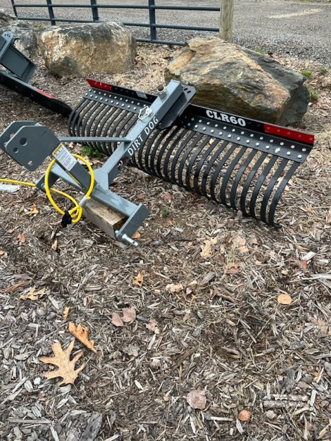 A rake is sitting on top of a pile of mulch.