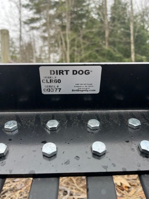 A dirt dog is sitting on top of a metal fence.
