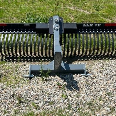 A rake is sitting on top of a gravel road.