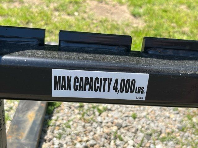 A metal bar with a sticker on it that says `` max capacity 4000 lbs ''.