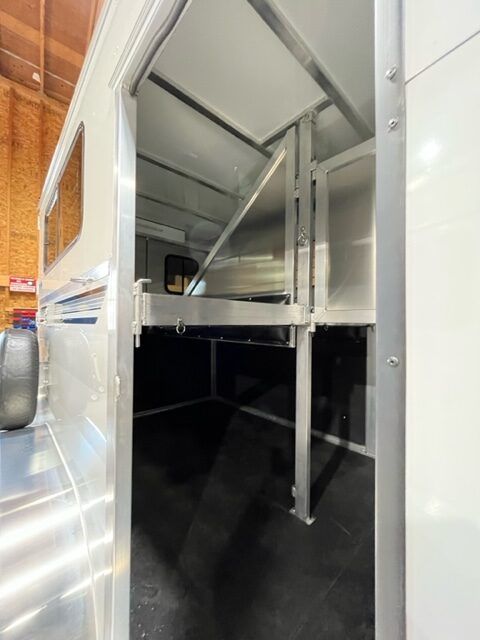 The inside of a horse trailer with the door open.