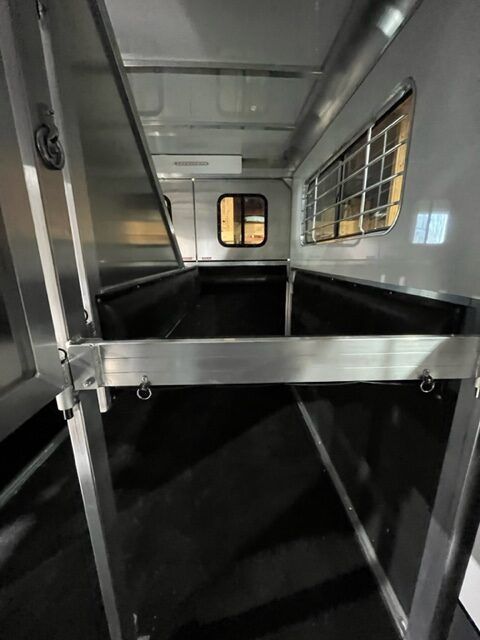 The inside of a horse trailer with a lot of windows