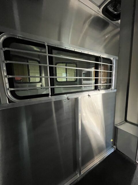 A close up of a stainless steel wall with a window.