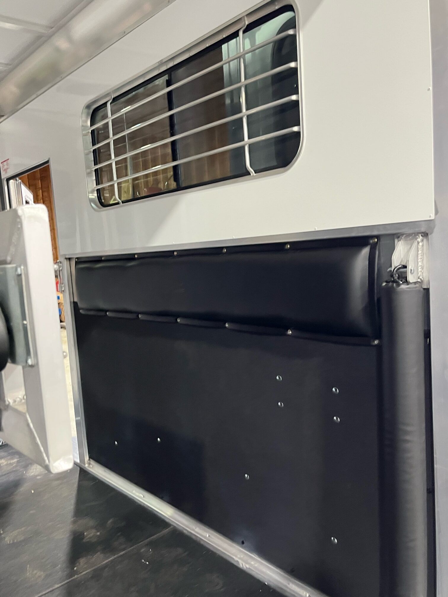 A horse trailer with a black wall and a window.