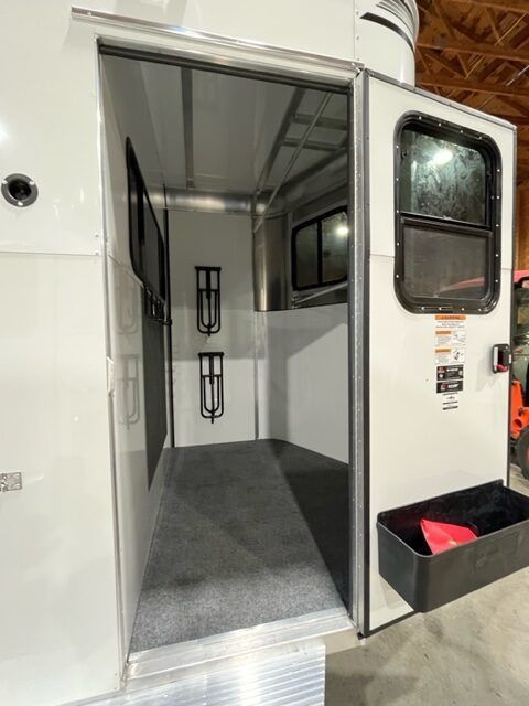 The inside of a horse trailer with the door open.