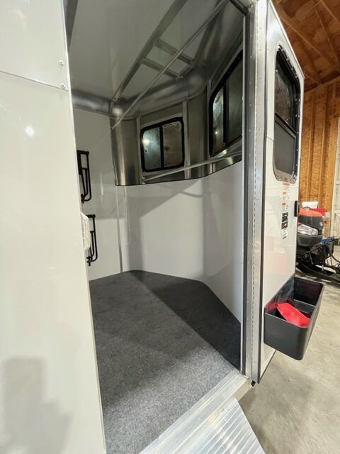 The inside of a white trailer with a gray carpet