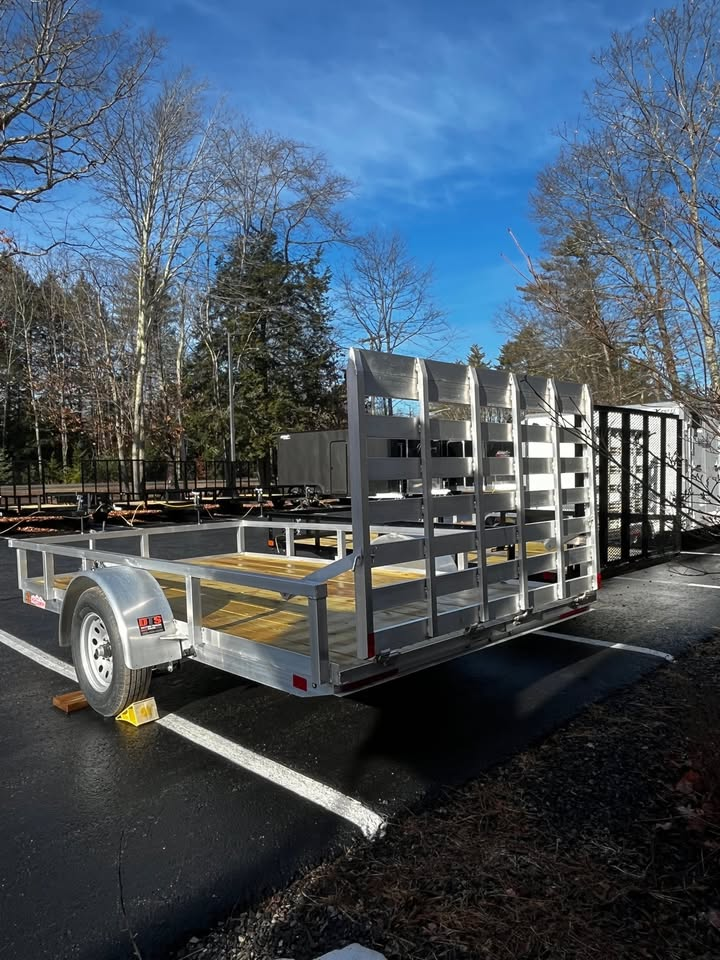 A trailer is parked on the side of the road in a parking lot.