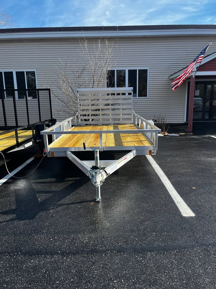 A trailer is parked in a parking lot in front of a building.