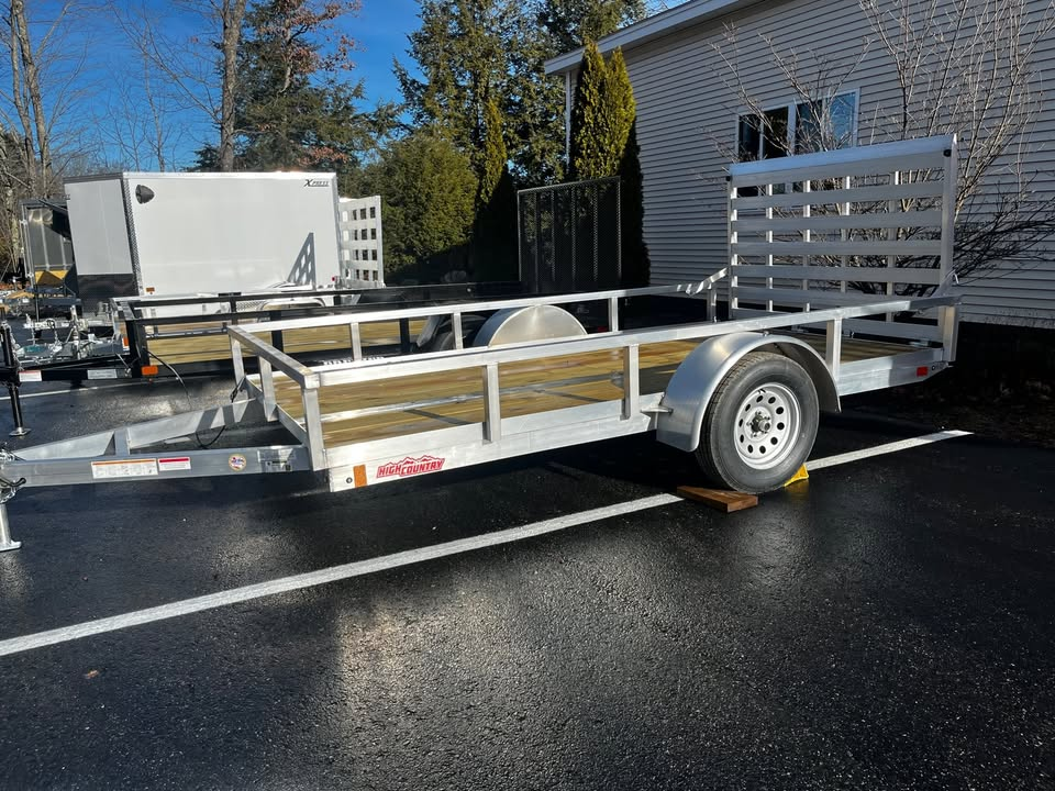 A trailer is parked in a parking lot in front of a house.