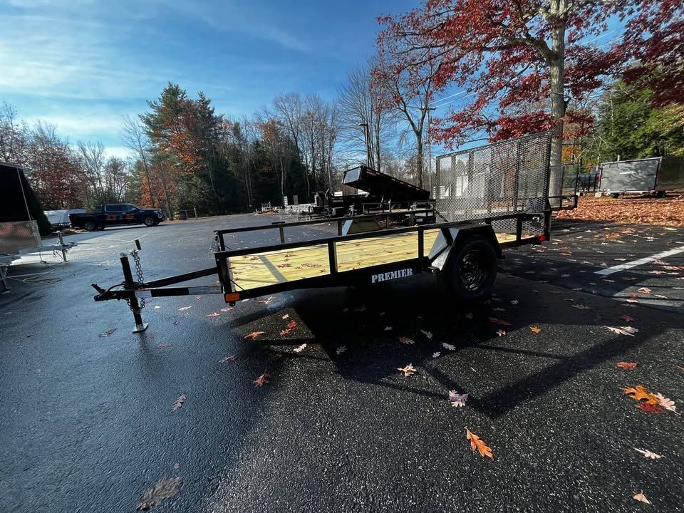 A small trailer is parked in a parking lot.