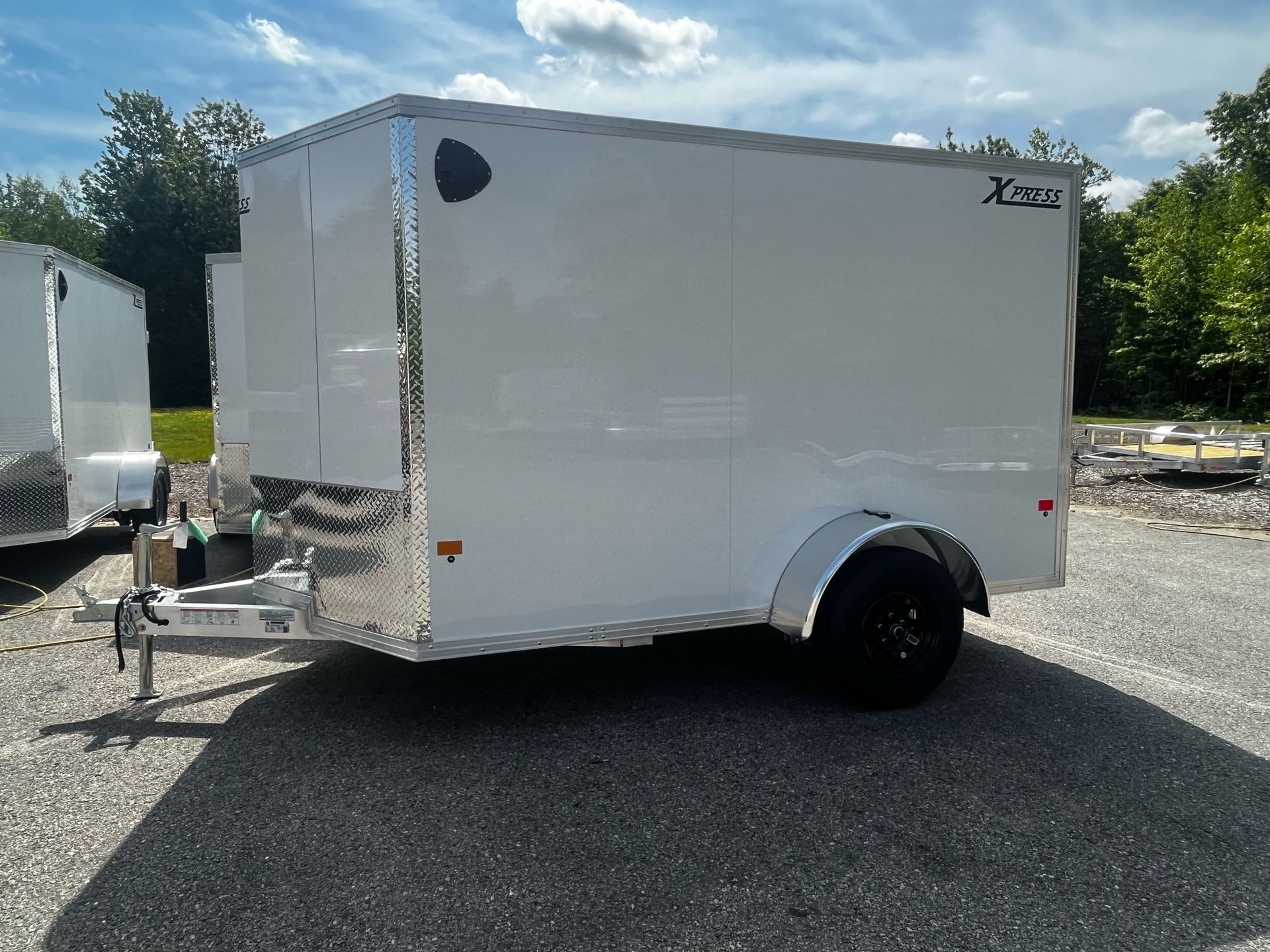 A white trailer is parked in a parking lot.