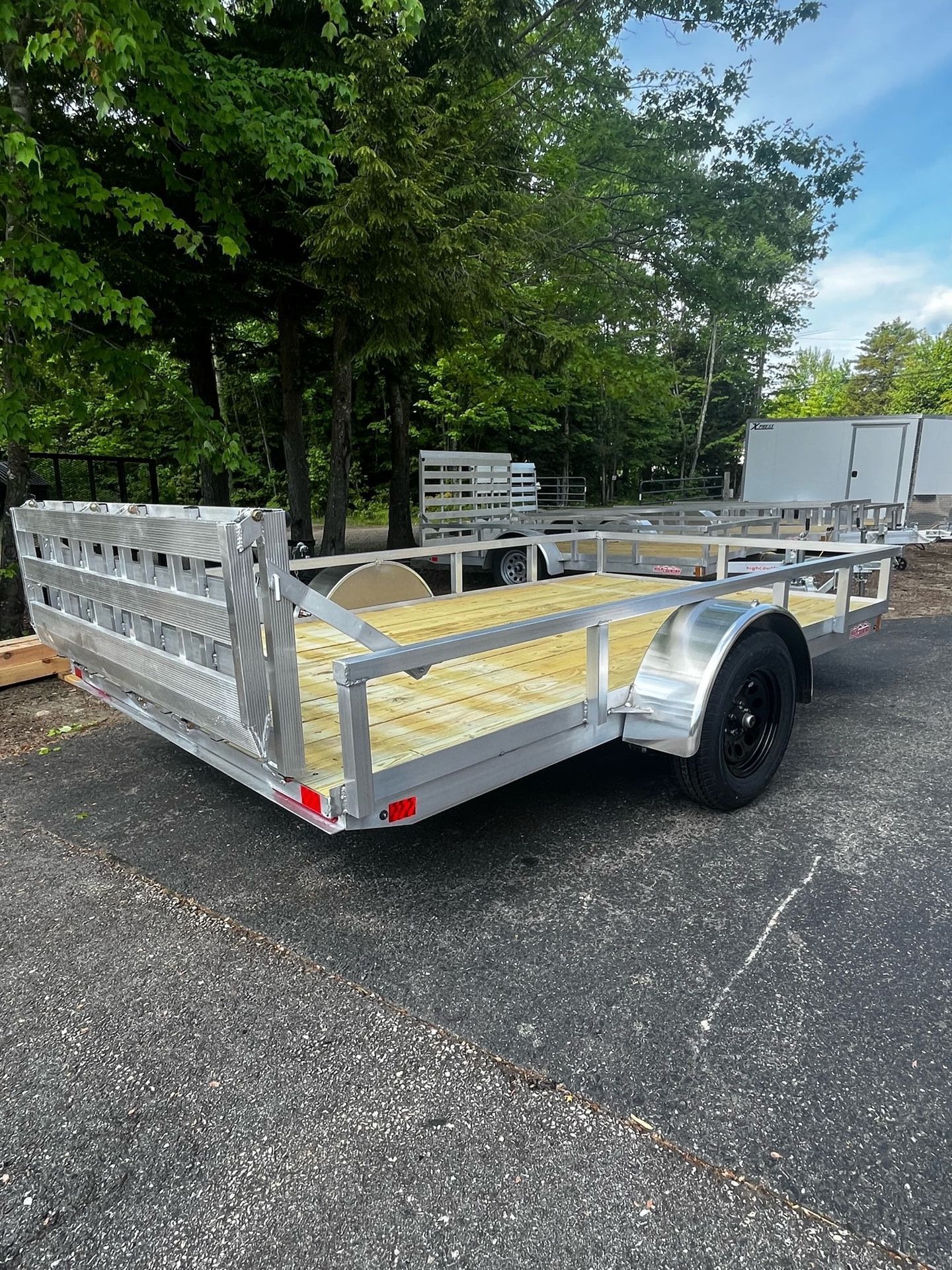 A small trailer is parked on the side of the road.