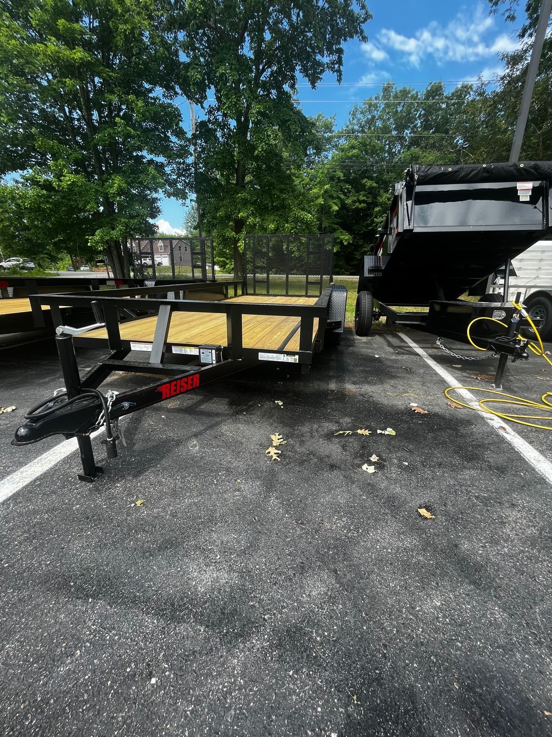 A trailer is parked in a parking lot next to a truck.