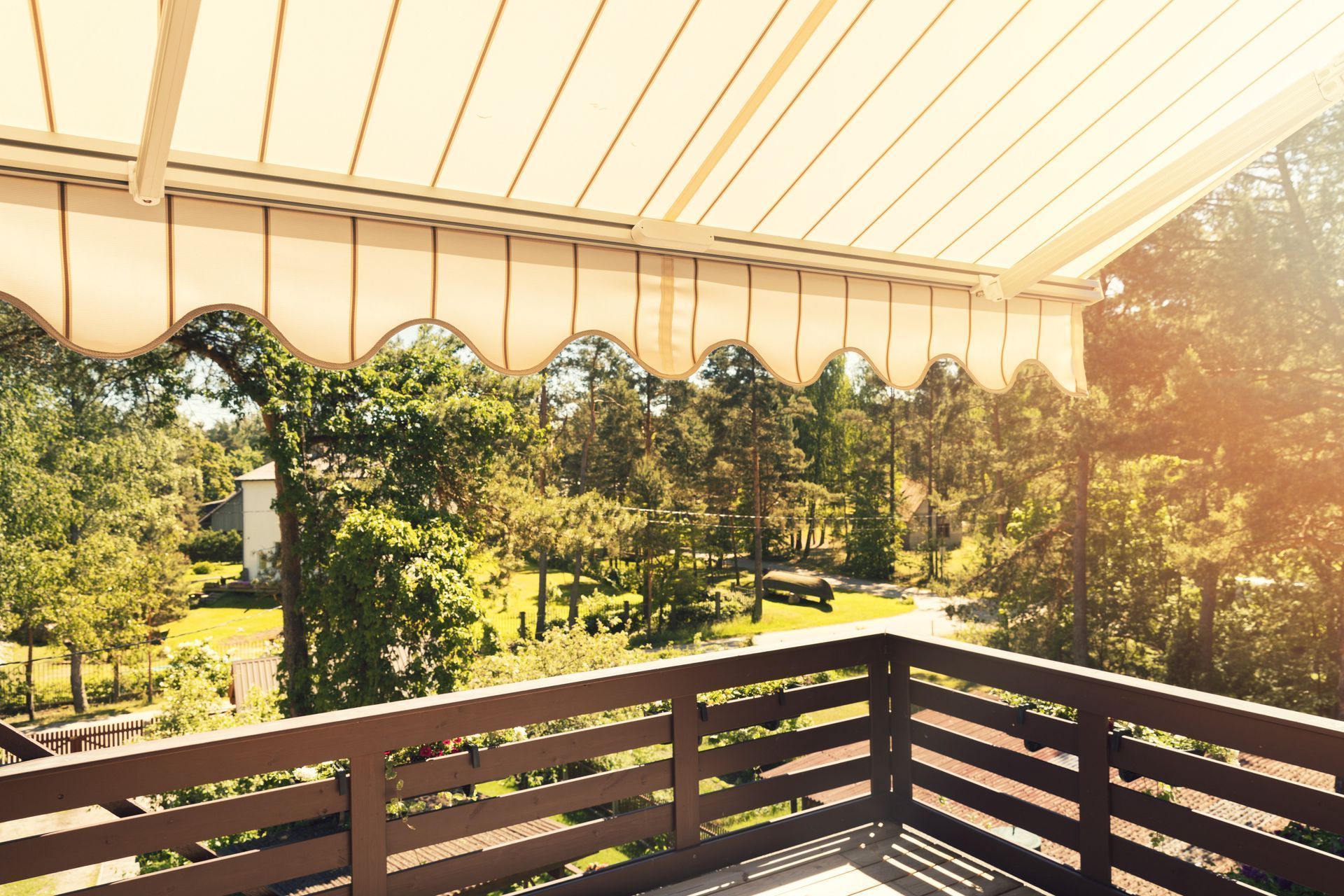 A balcony with a canopy over it and trees in the background.
