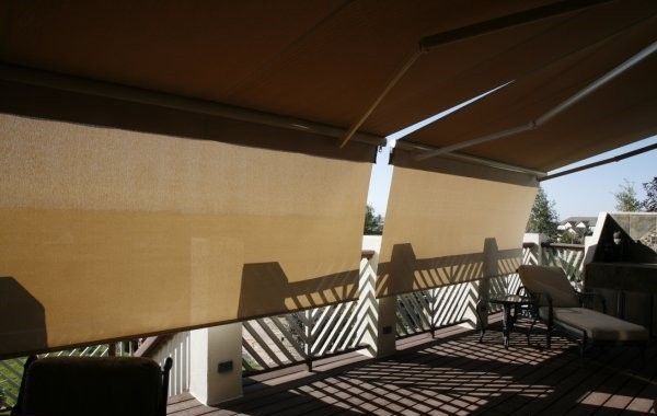 A deck with a table and chairs under an awning