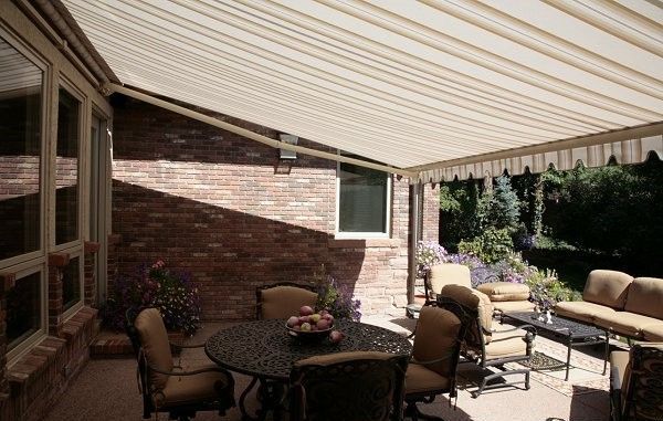 A patio with a table and chairs under an awning