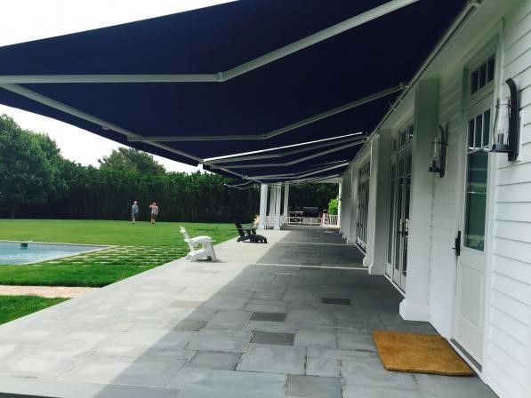 A white house with a blue awning over it