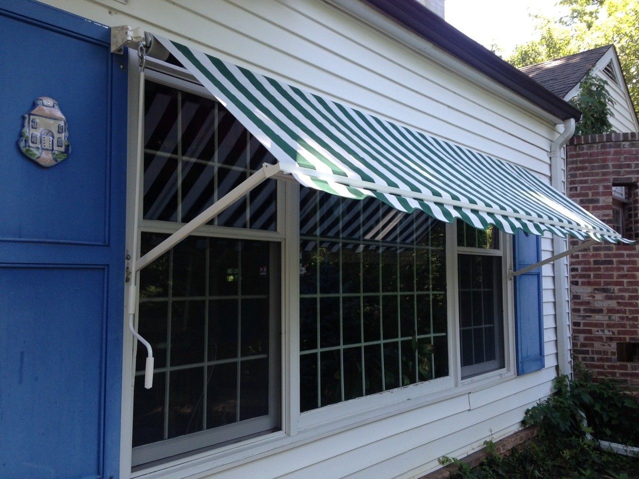 A window with a green and white awning on it