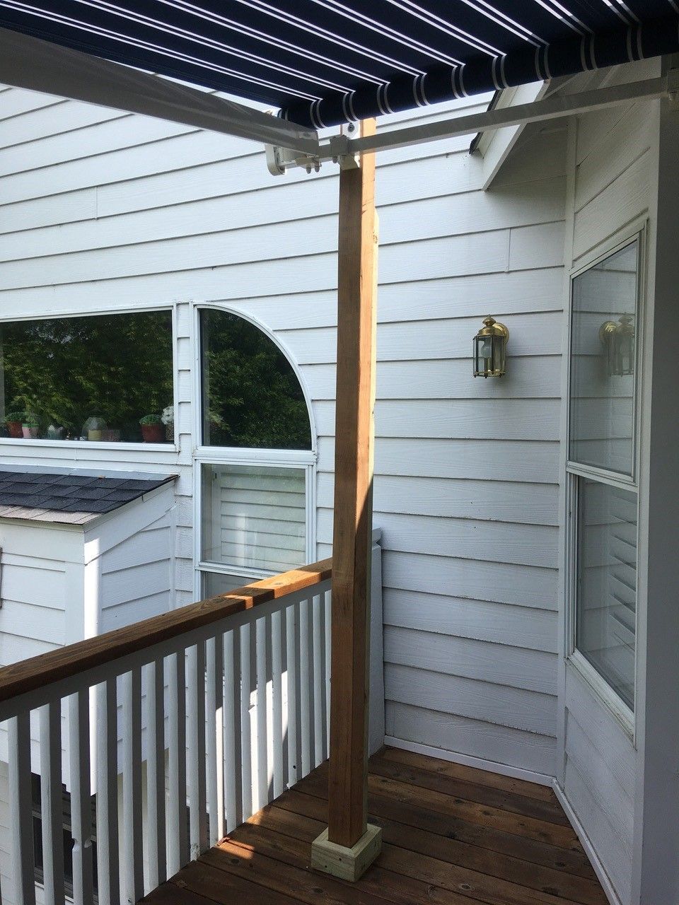 A balcony with a blue and white awning over it