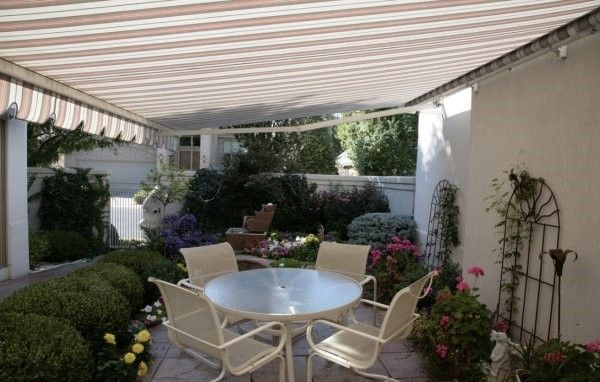 A patio with a table and chairs under an awning