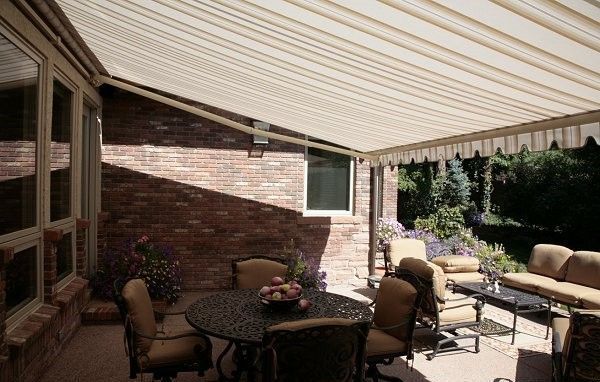 A patio with a table and chairs under an awning